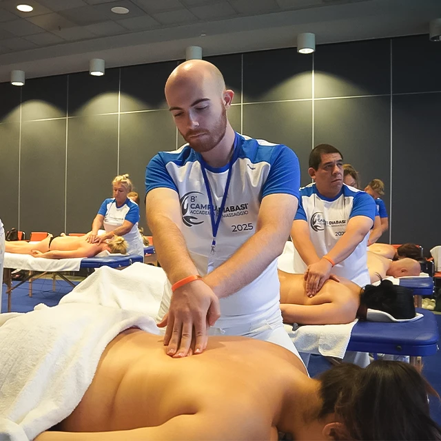 Allievi del Campus DIABASI eseguono tecniche di massaggio durante una sessione pratica guidata in aula