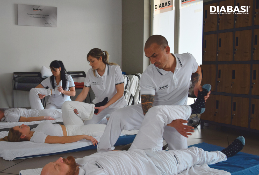Allievi eseguono tecniche di massaggio thailandese con stretching su futon durante un corso professionale. Diabasi