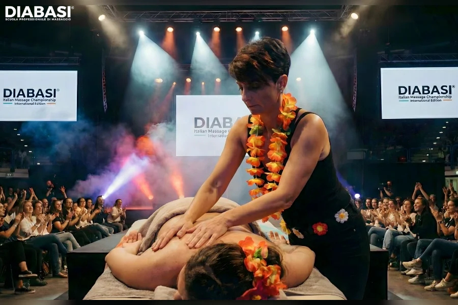 Una massaggiatrice Diabasi esegue correttamente il massaggio hawaiano Lomi Lomi Nui su una modella durante la Championship 2024, utilizzando la tecnica dell'onda con gli avambracci per favorire il rilassamento profondo. Scuola Professionale di Massaggio.