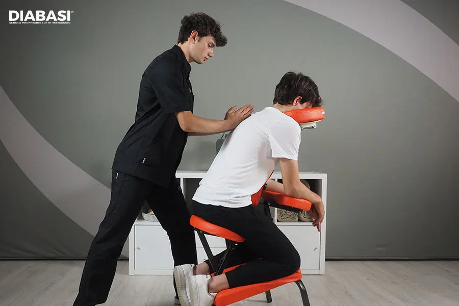 Manualità sulla schiena durante un massaggio su sedia ergonomica eseguito da operatore professionista