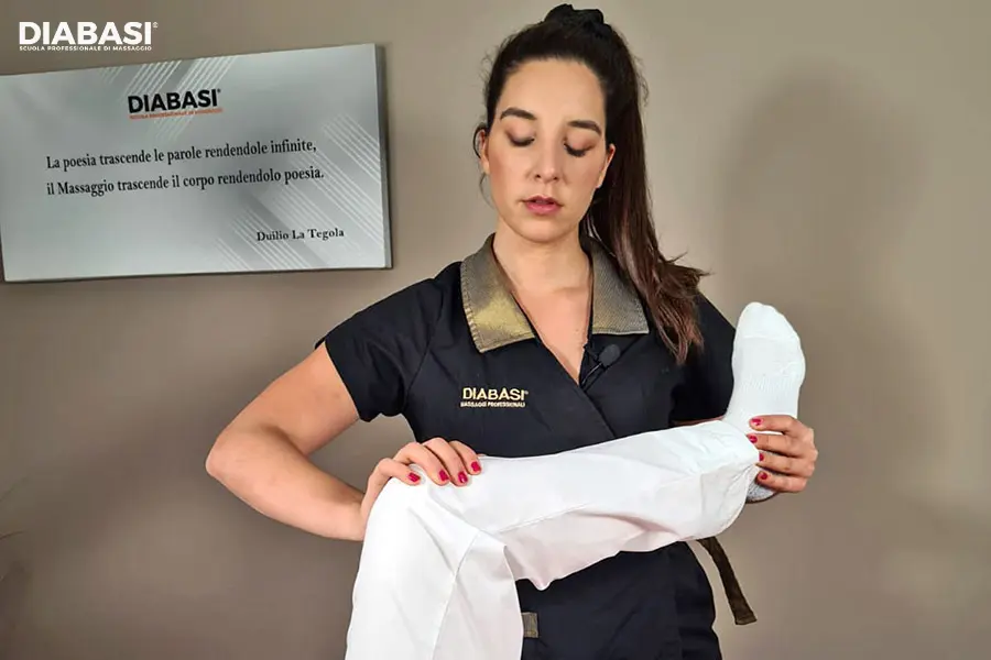 Operatrice specializzata esegue manovre di stretching passivo sul lettino per la flessibilità articolare del ginocchio.
